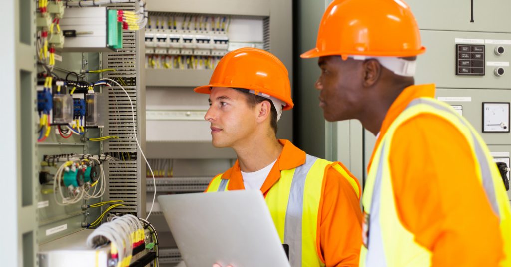 Electrical worker inspecting industrial equipment.